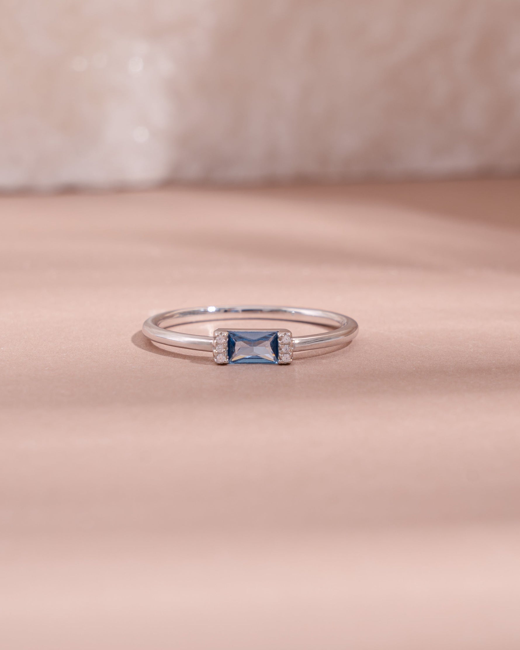 sterling silver aquamarine diamond baguette birthstone ring light pink background