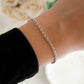 Close up of sterling silver minimalist rolo chain bracelet worn on woman's wrist.