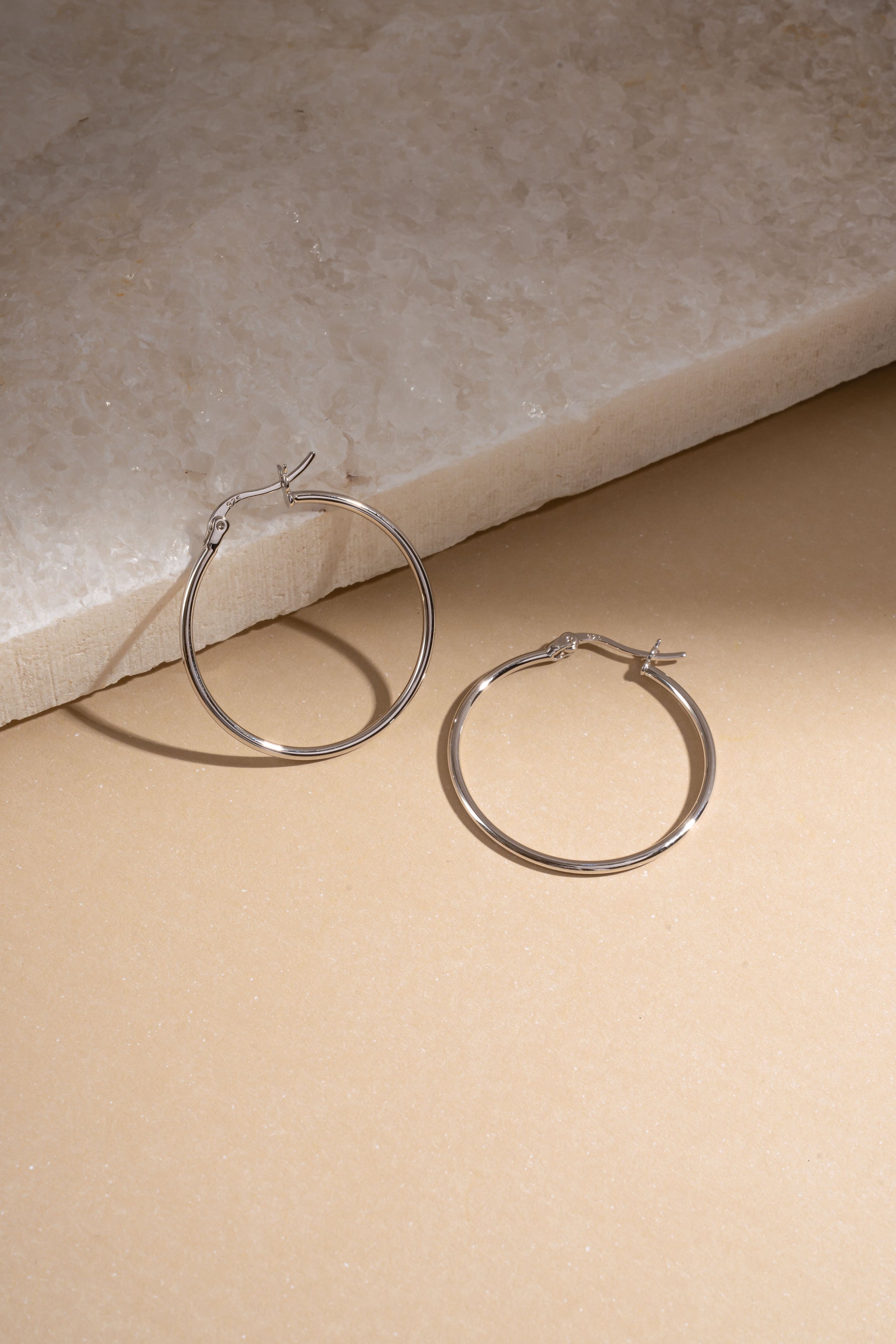 sterling silver classic hoop earrings in 30mm size neutral background