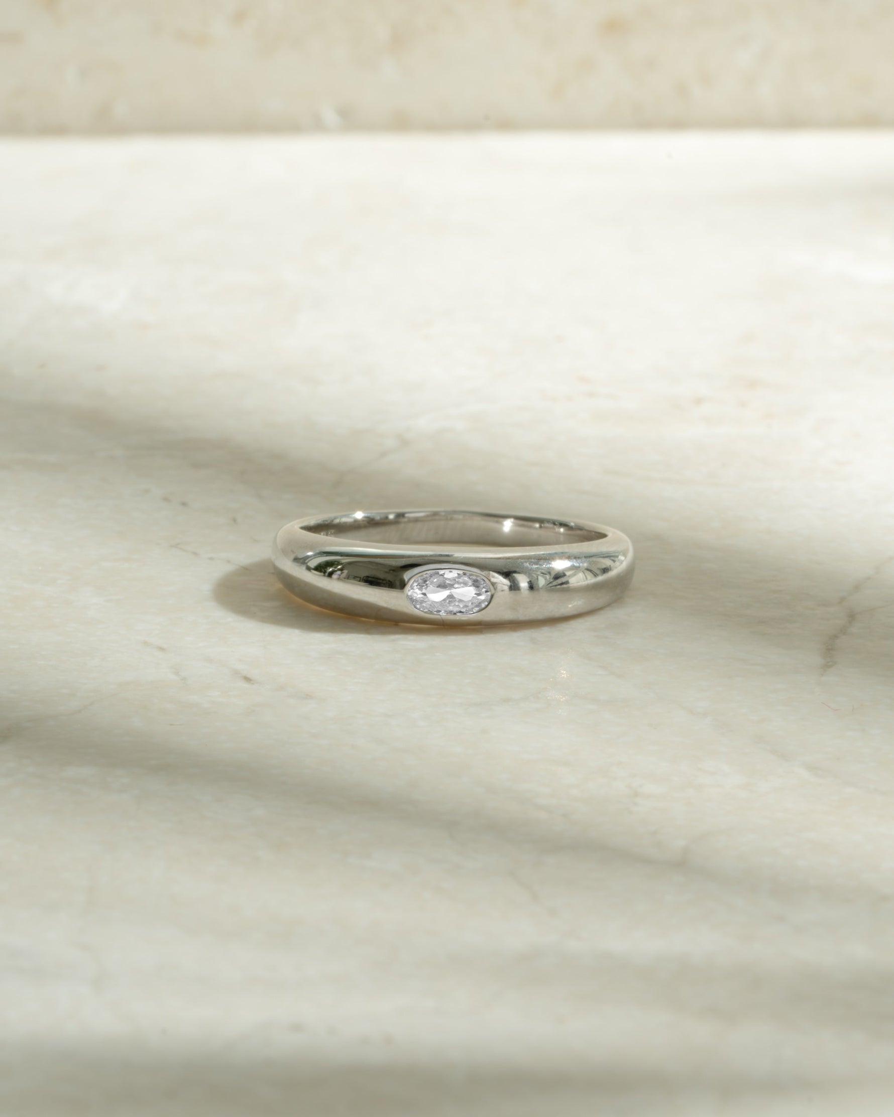 sterling silver bezeled dome ring on neutral background
