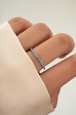 sterling silver blue topaz eternity ring on models hand 