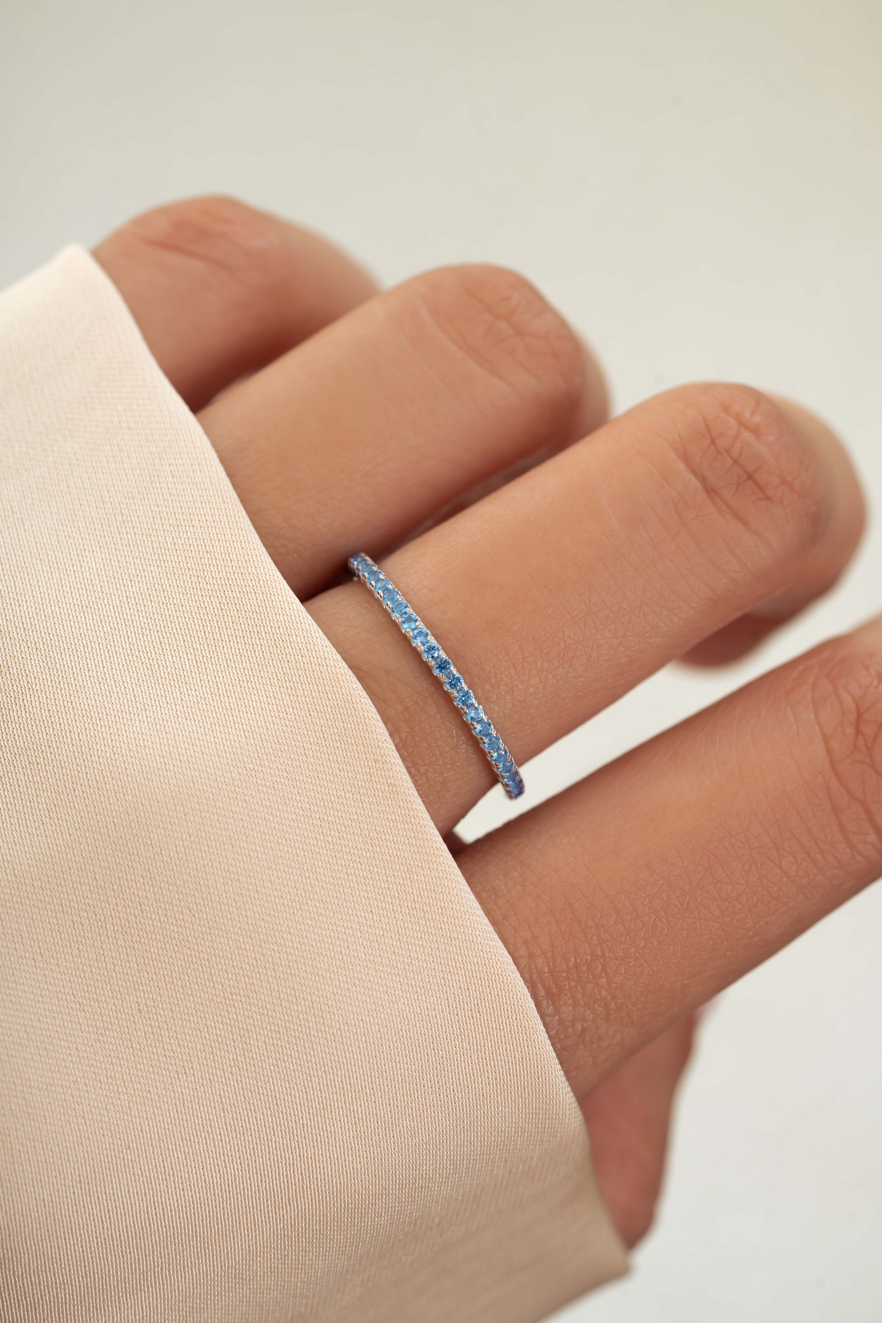 sterling silver blue topaz eternity ring on models hand 