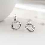 Close-up of interwoven knot design, showcasing the intricate craftsmanship of these silver hoops. 