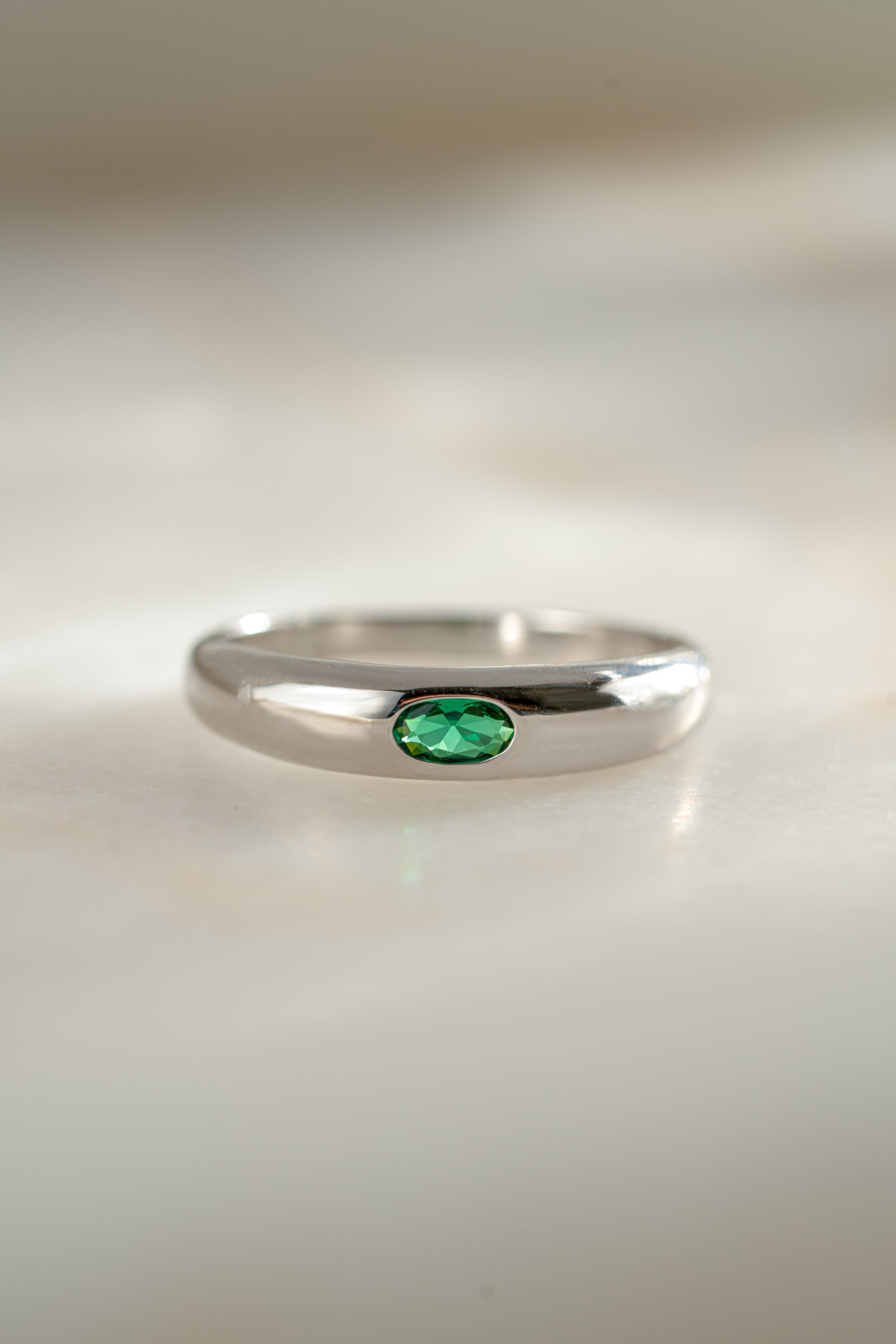 sterling silver emerald bezel set dome ring neutral background 