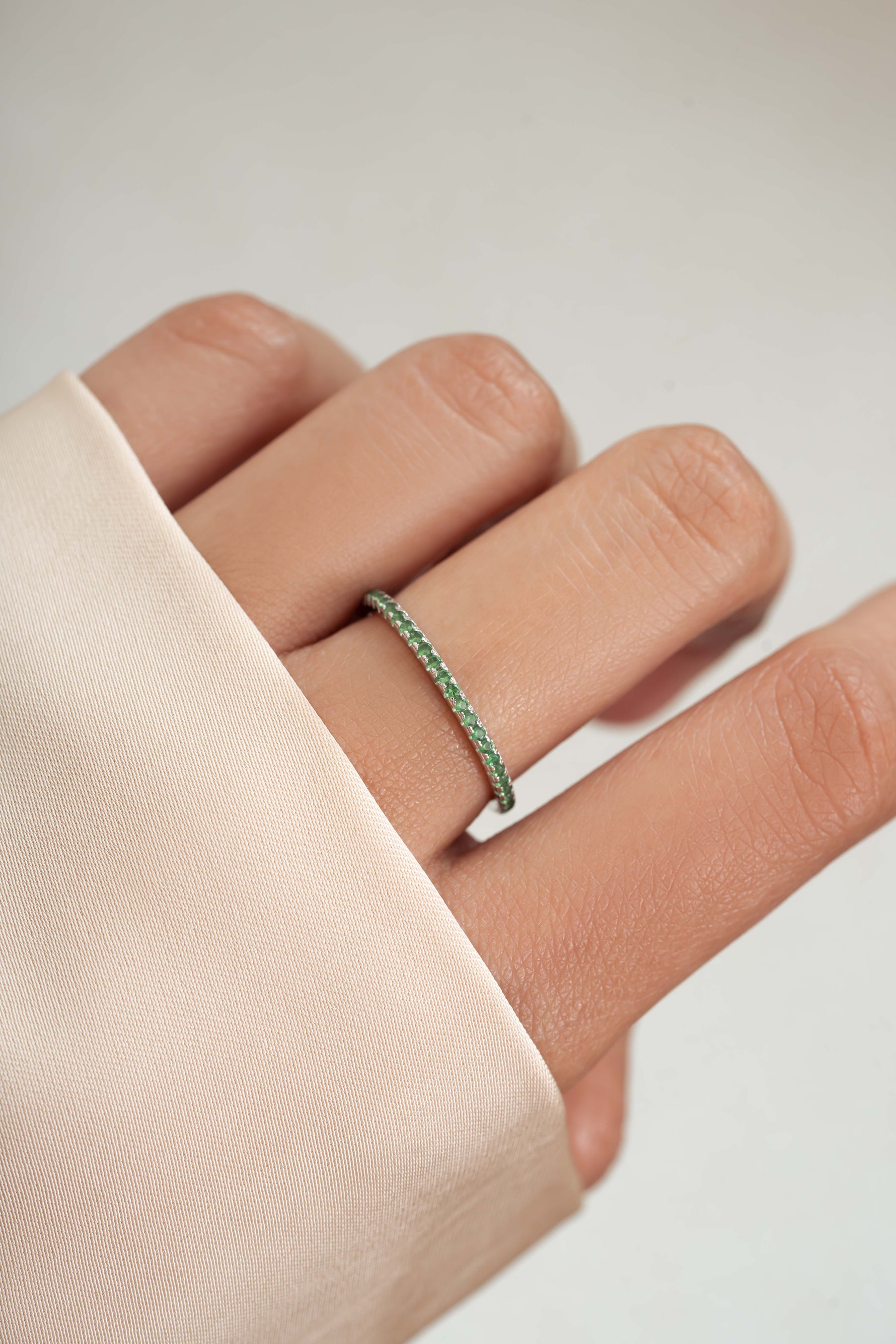 sterling silver emerald birthstone eternity ring on womens hand