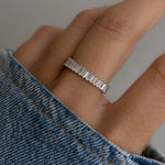 model wearing a gemstone ring with its diamonds complementing soft skin tones. 