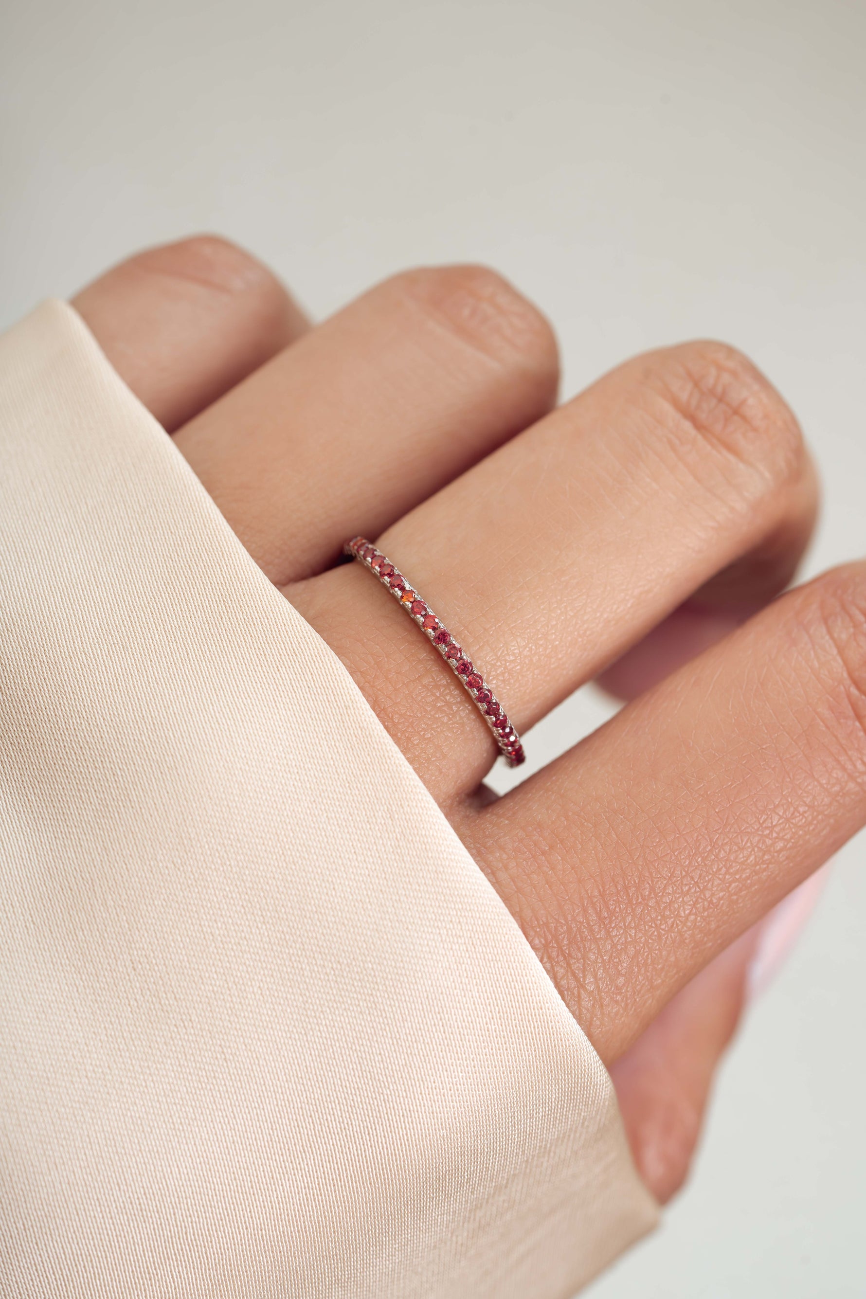 sterling silver garnet eternity ring on womens hand 