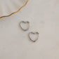 Sterling silver heart hoop earrings on white marble background