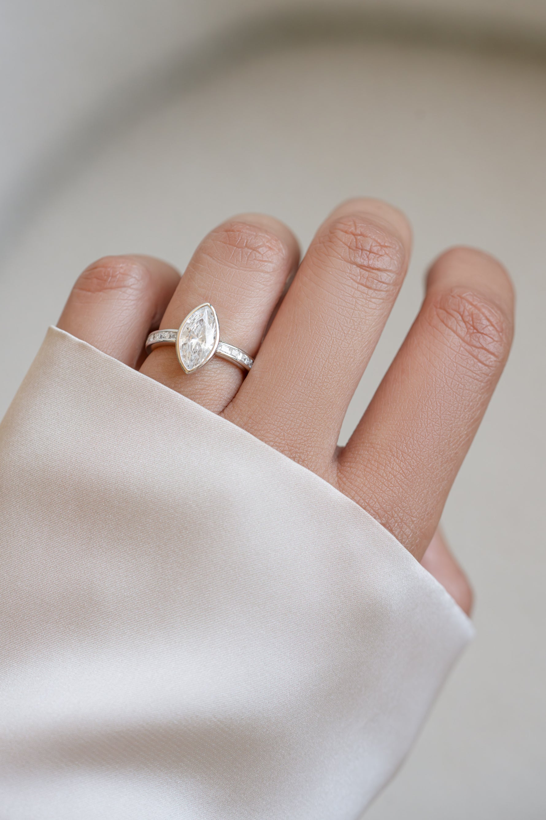 Sterling silver Bezel Marquise Ring with baguette band from Sami Jewels worn on a model's finger.