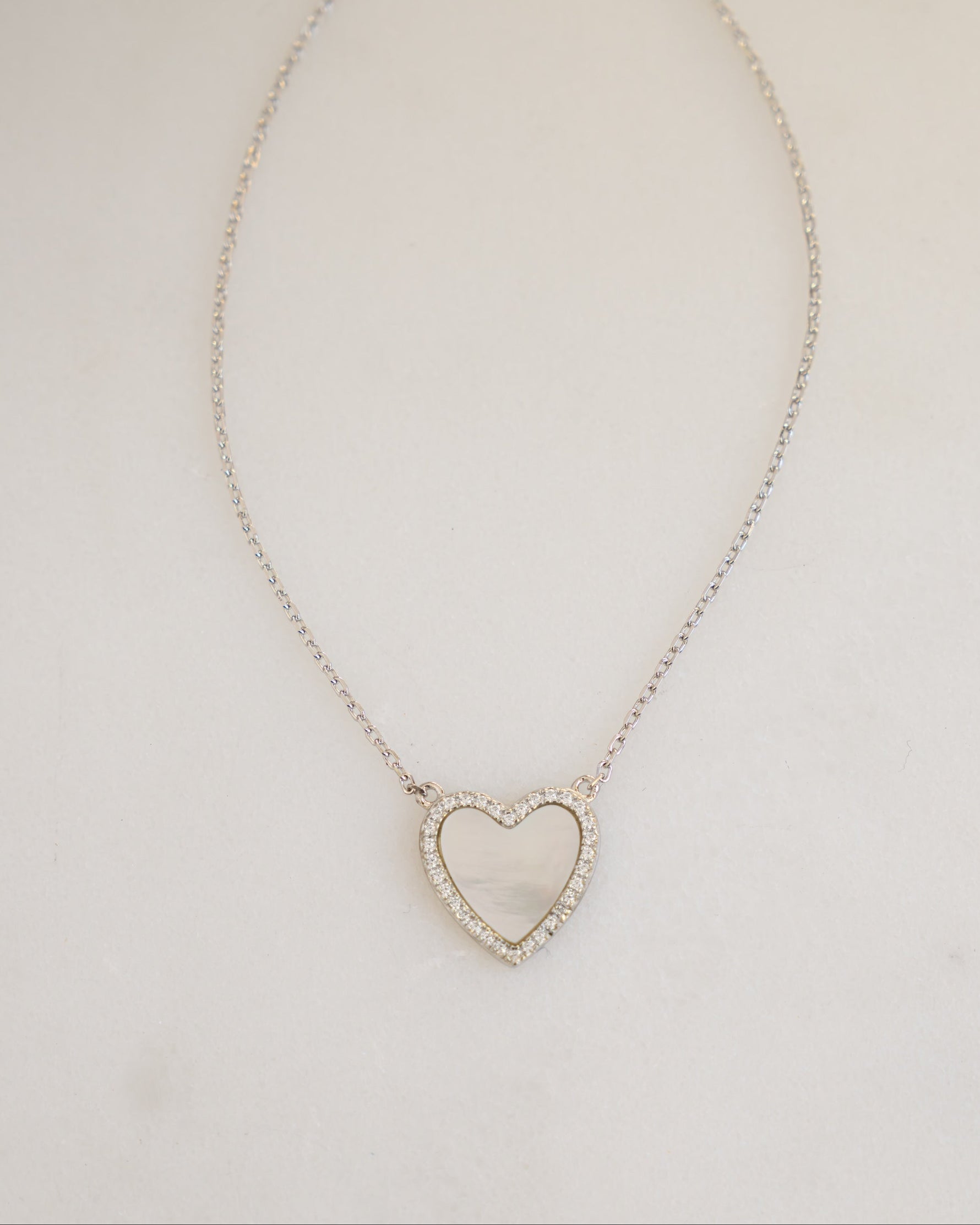 sterling silver mother of pearl heart pendant necklace on neutral surface