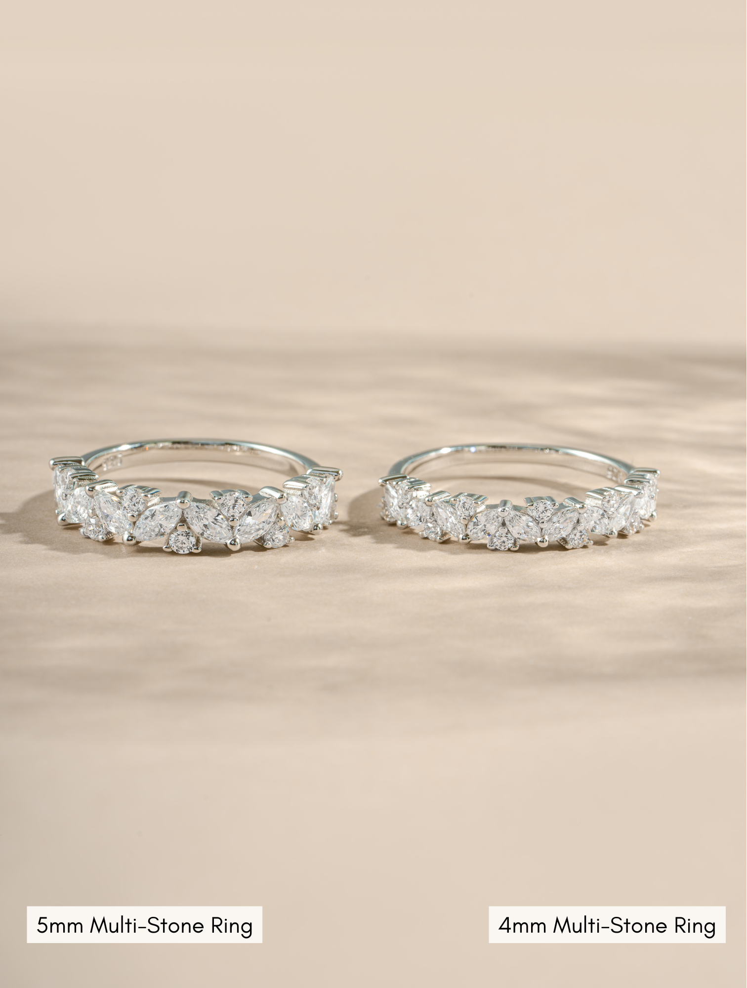 5mm sterling silver multistone ring compared to a 4mm sterling silver multi stone ring on a neutral background