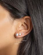 sterling silver cubic zirconia stud earrings in various sizes, pear stud earring in 5x7mm, followed by a 4x6mm pear stud earring, and lastly, a 2x3mm pear stud earring on womens ear 