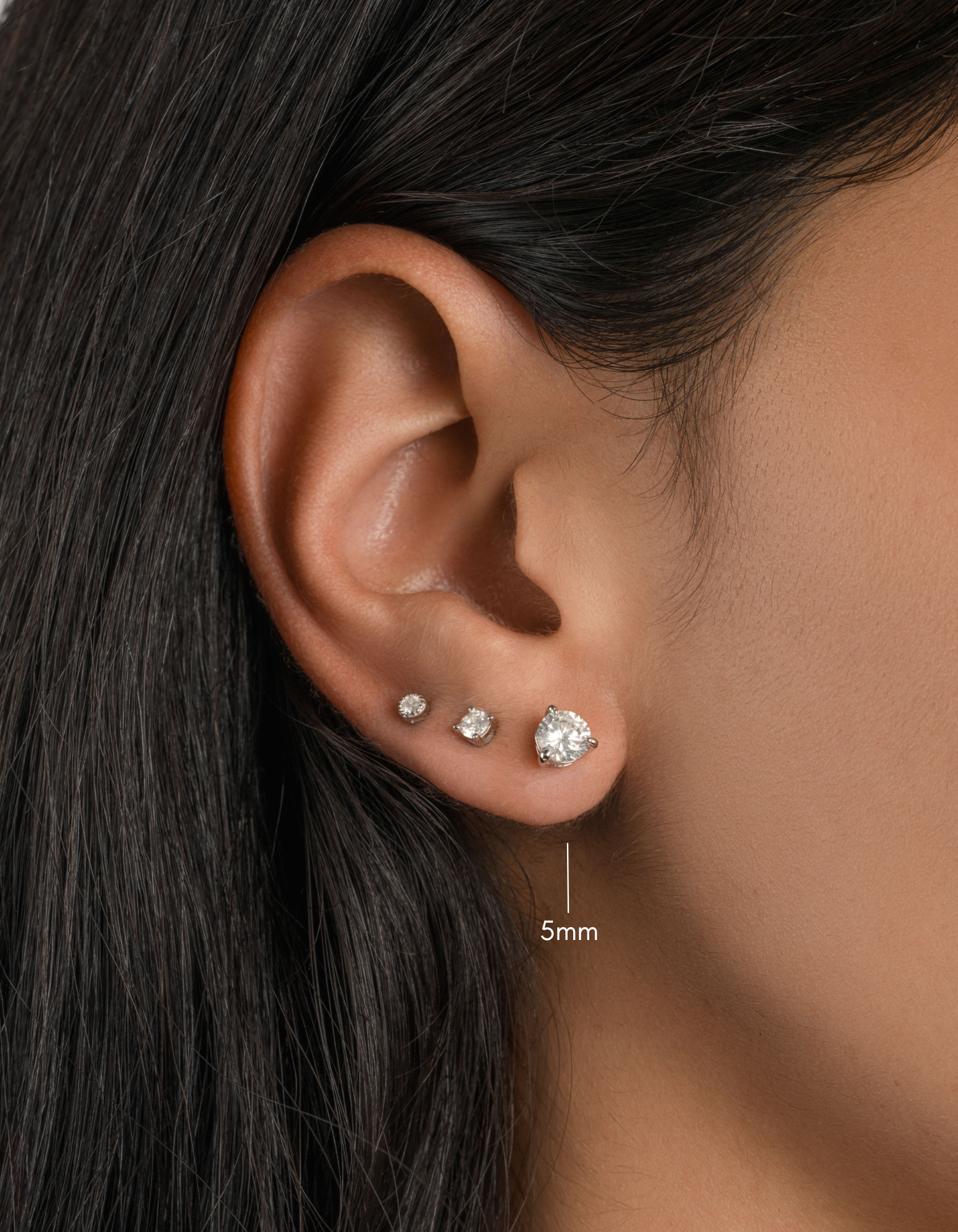 sterling silver round solitaire stud earring on womens ear 