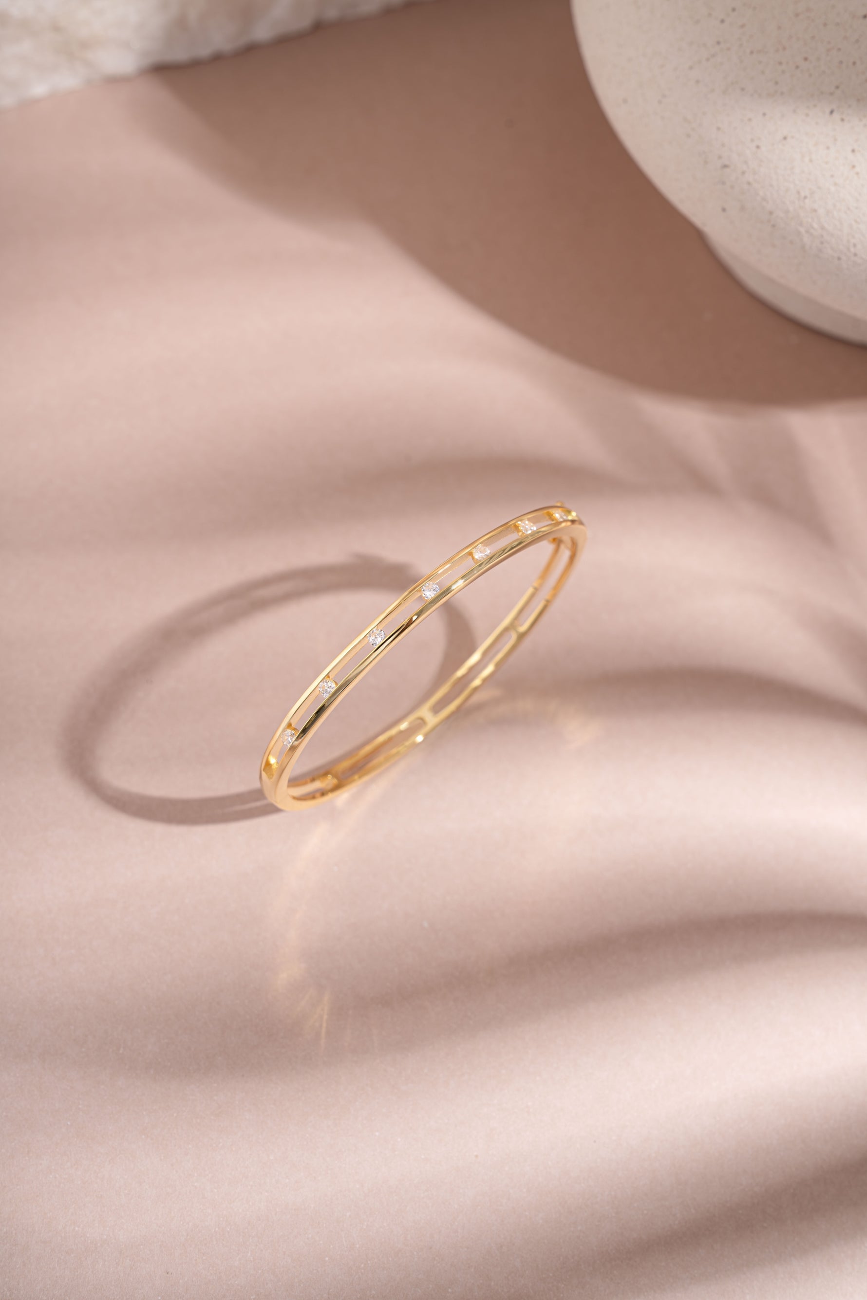 Gold Sami Jewels studded diamond bangle viewed from the top, showcasing its elegant design and sparkling embellishments.