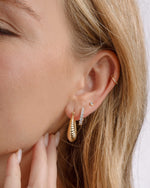 Gold studded hoop earrings from Sami Jewels, stylish earrings with small metal studs on large hoops, worn by a model.