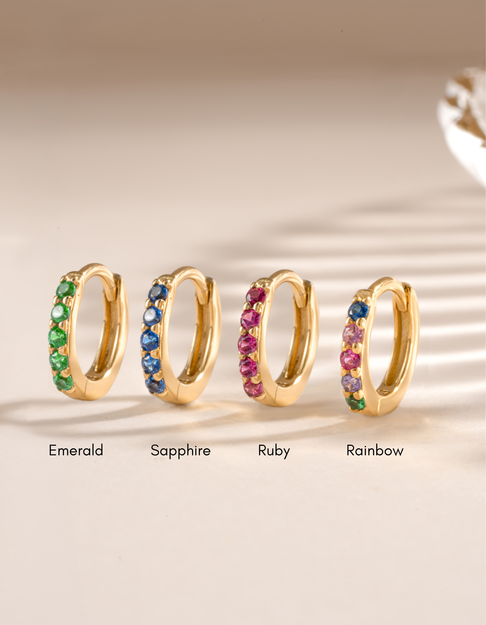 7mm emerald studded huggie earrings by Sami Jewels, gold-plated hoop earrings with vibrant emerald gemstones.