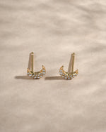Gold studded moon earrings from Sami Jewels, featuring a celestial design with small metallic studs in an angled view.