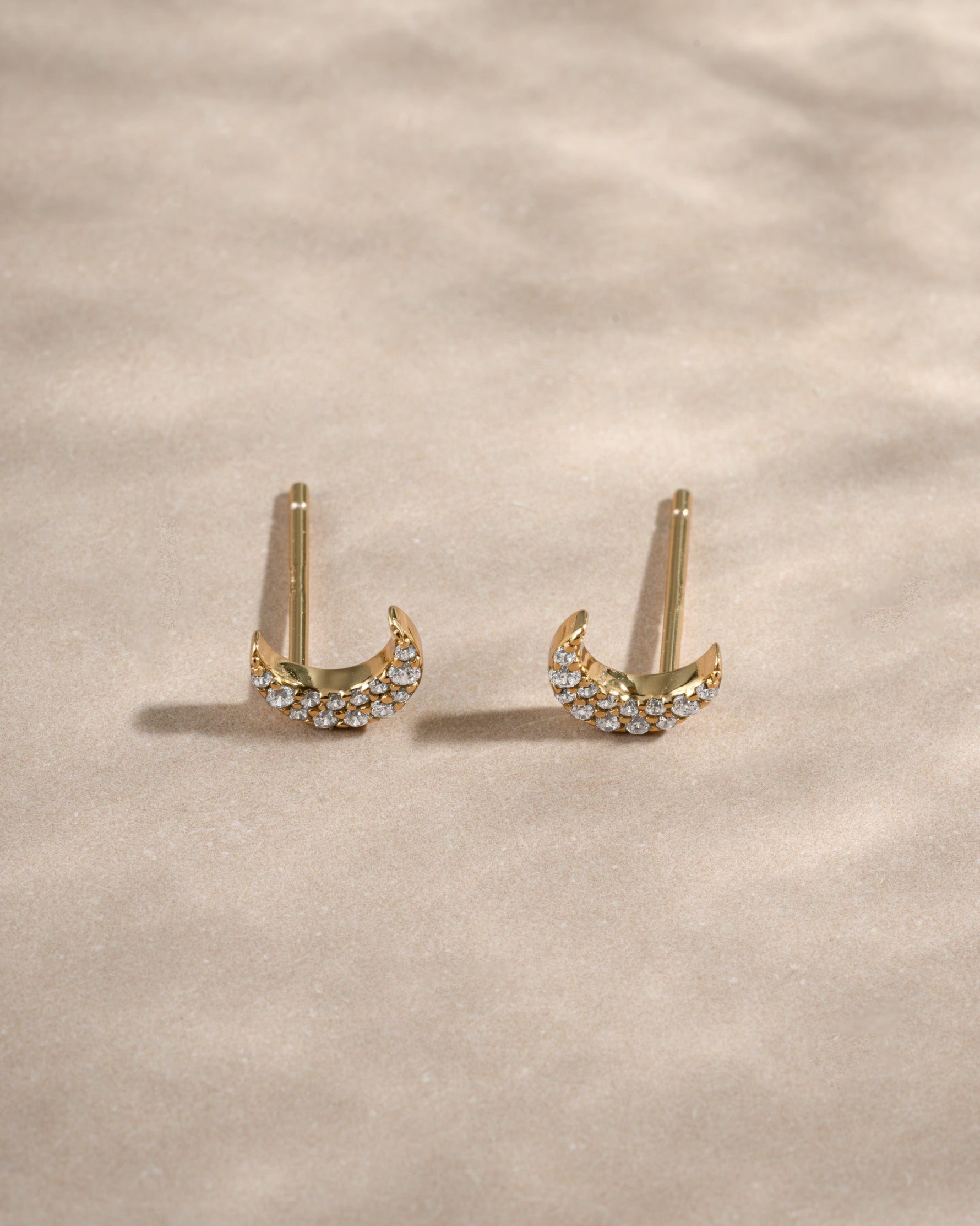 Gold studded moon earrings from Sami Jewels, featuring a celestial design with small metallic studs in an angled view.