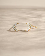 Gold studded moon earrings by Sami Jewels, featuring small crescent-shaped studs with metallic accents and a sleek design.