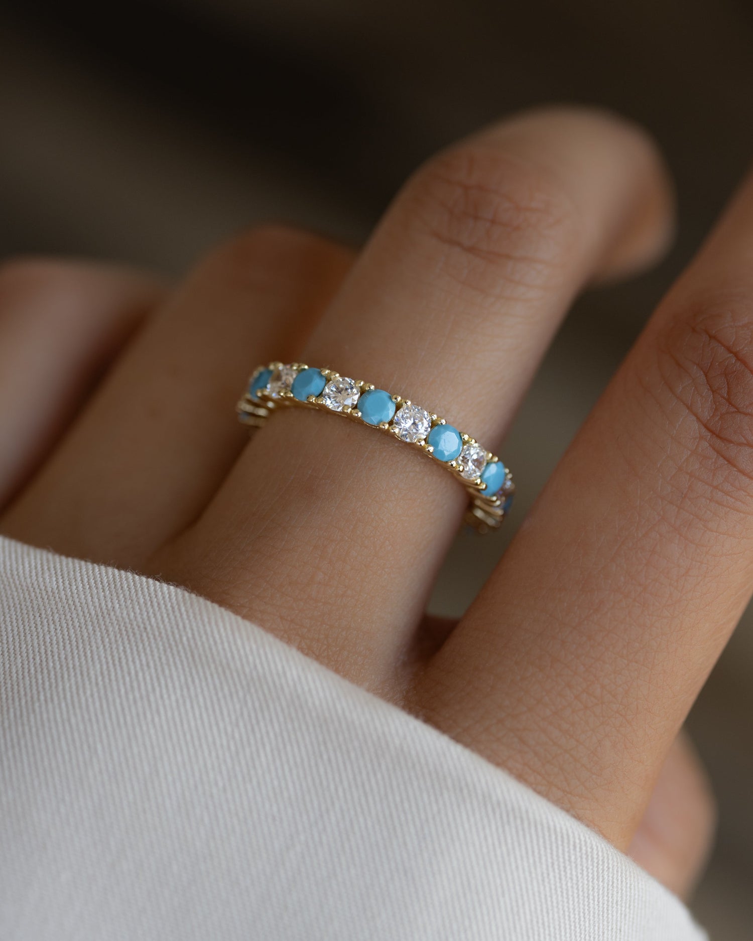 Sami Jewels 3mm turquoise eternity ring with gold band featuring evenly spaced studded turquoise stones.