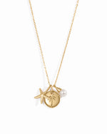 beach charm necklace with a starfish charm, palm tree medallion charm, and a pear charm in gold