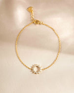 sunburst charm bracelet in gold on simple background