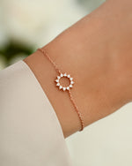 sunburst charm bracelet in rose gold on models wrist 