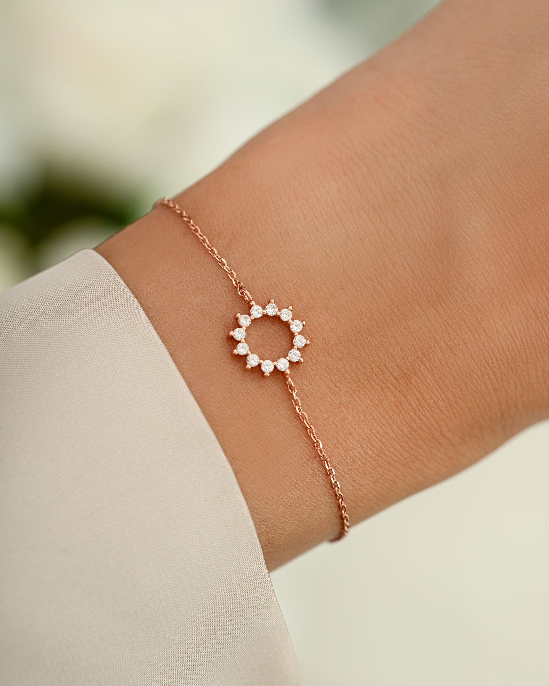 sunburst charm bracelet in rose gold on models wrist 
