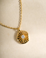 Close-up of a gold Sunburst Medallion Necklace by Sami Jewels featuring intricate sunburst design on a delicate chain.