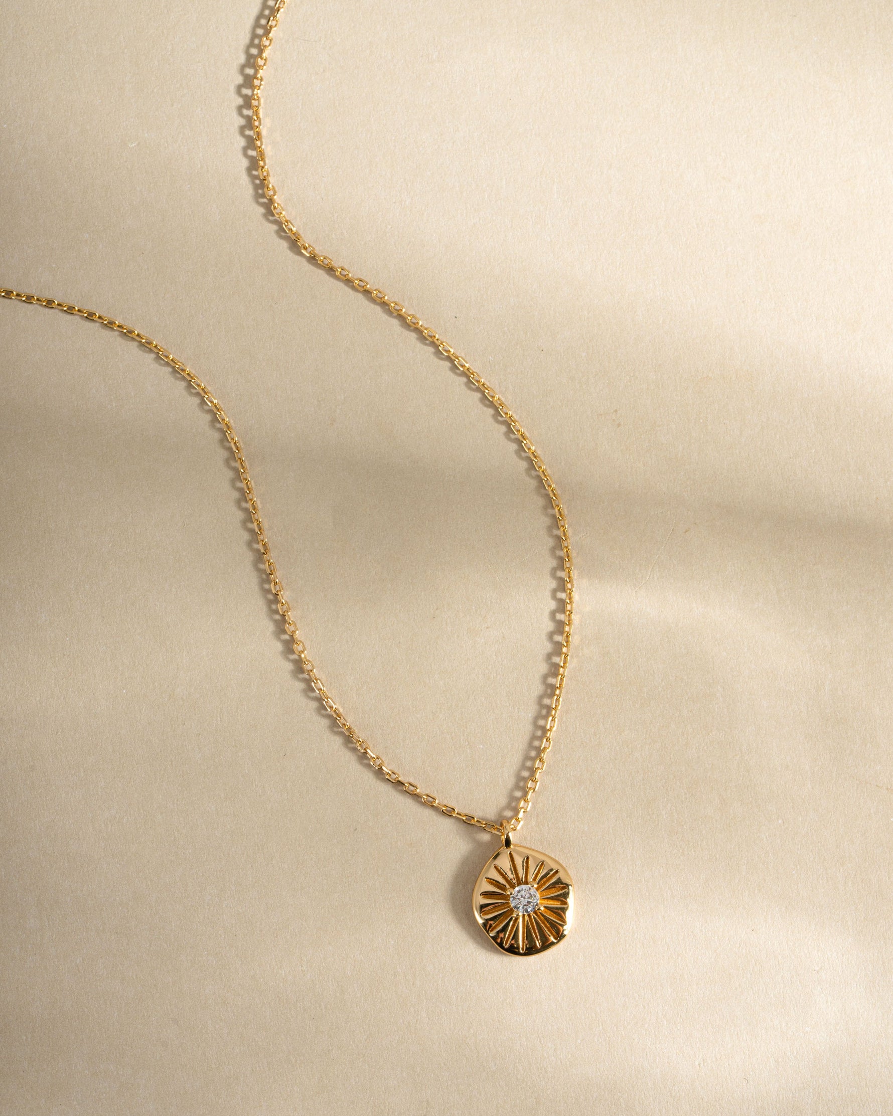 Gold Sunburst Medallion Necklace from Sami Jewels featuring a detailed sunburst design, front view showcasing its elegant pendant.