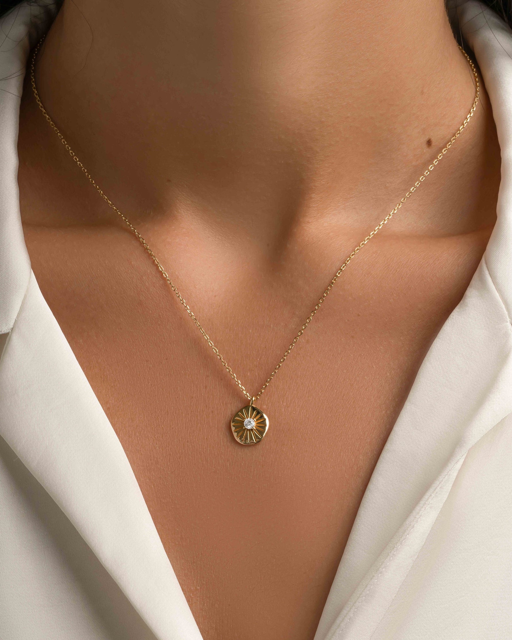 Gold Sunburst Medallion Necklace from Sami Jewels featuring a detailed sunburst pendant on a delicate chain