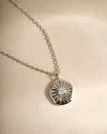 Close-up of Sami Jewels Sunburst Medallion Necklace featuring a sterling silver sunburst pendant on a delicate chain.