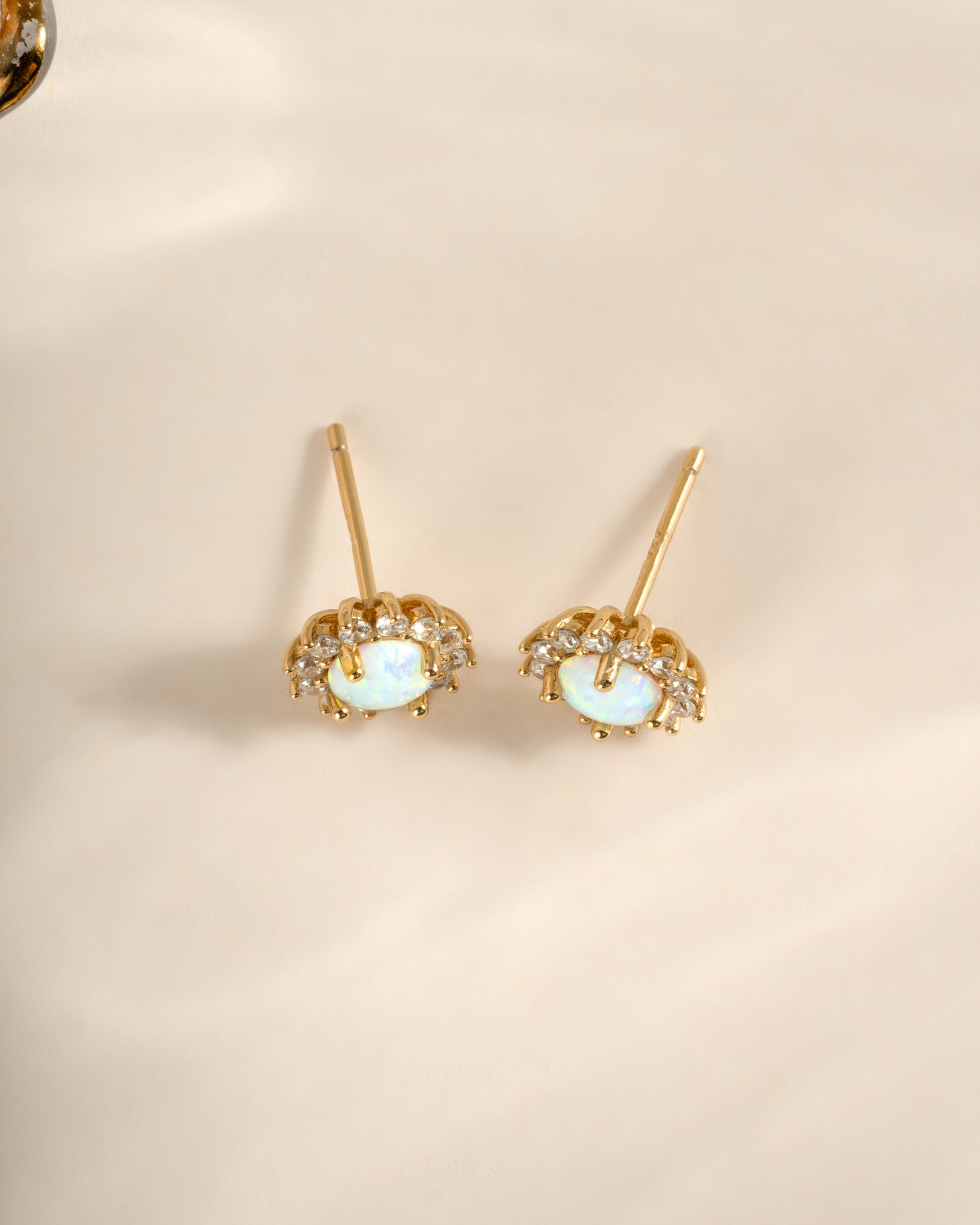Sami Jewels Sunburst Opal Halo Stud Earrings with radiant opal center and sparkling halo design, top view.