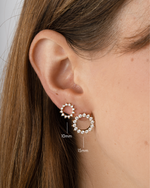 Gold 15mm Sunburst Stud Earrings from Sami Jewels, shown in various sizes on a model.