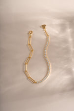 Close-up of Sami Jewels gold tennis and paperclip bracelet showing intertwined chain design and shiny finish.