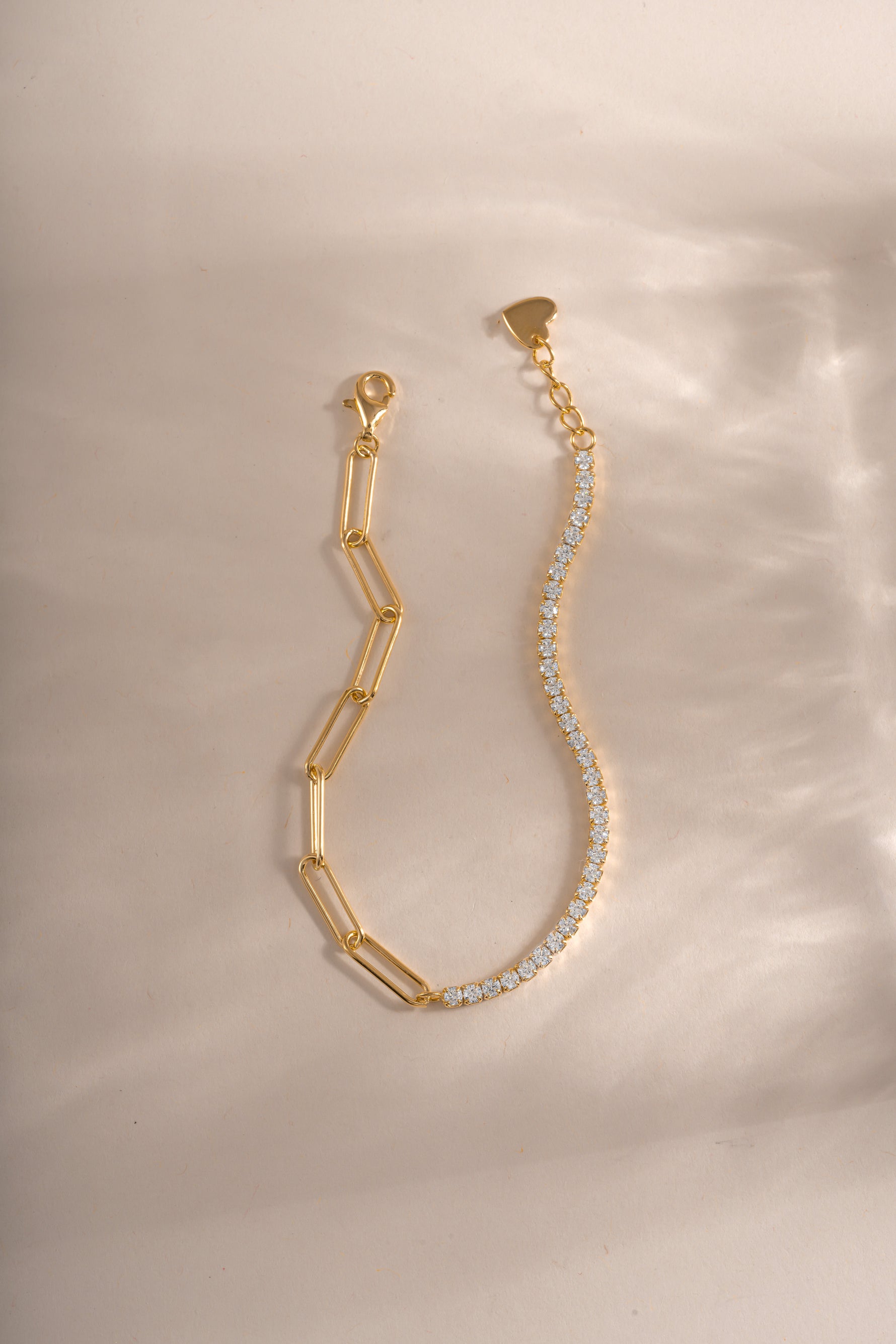 Close-up of Sami Jewels gold tennis and paperclip bracelet showing intertwined chain design and shiny finish.