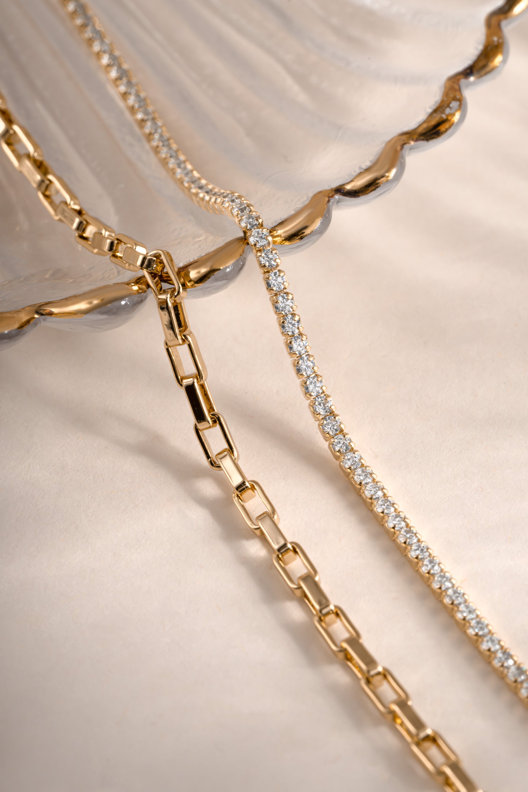 Close-up of Sami Jewels gold tennis and paperclip bracelet set showing sleek, modern design on a plain background.