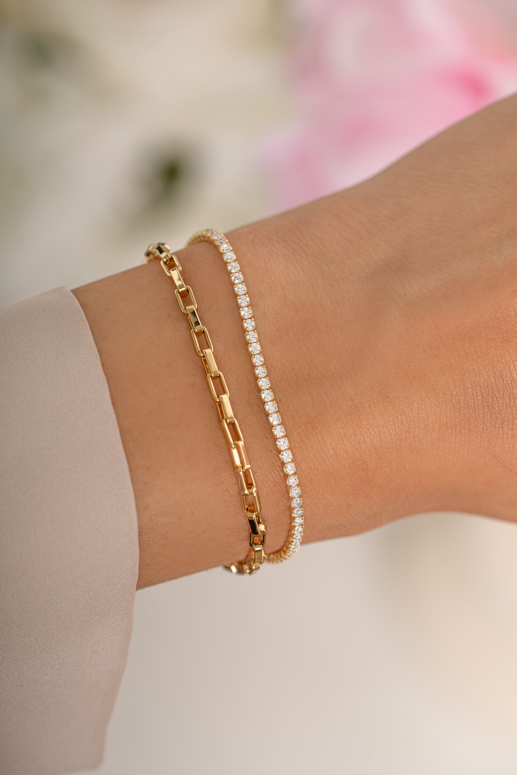 Gold tennis and paperclip bracelet set by Sami Jewels featuring sleek, minimalist designs on a model's wrist.