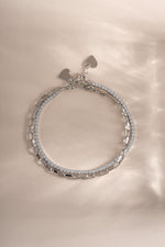 Close-up of Sami Jewels Sterling Silver Tennis & Paperclip Bracelet Set showcasing sleek, modern bracelet designs on a neutral background.