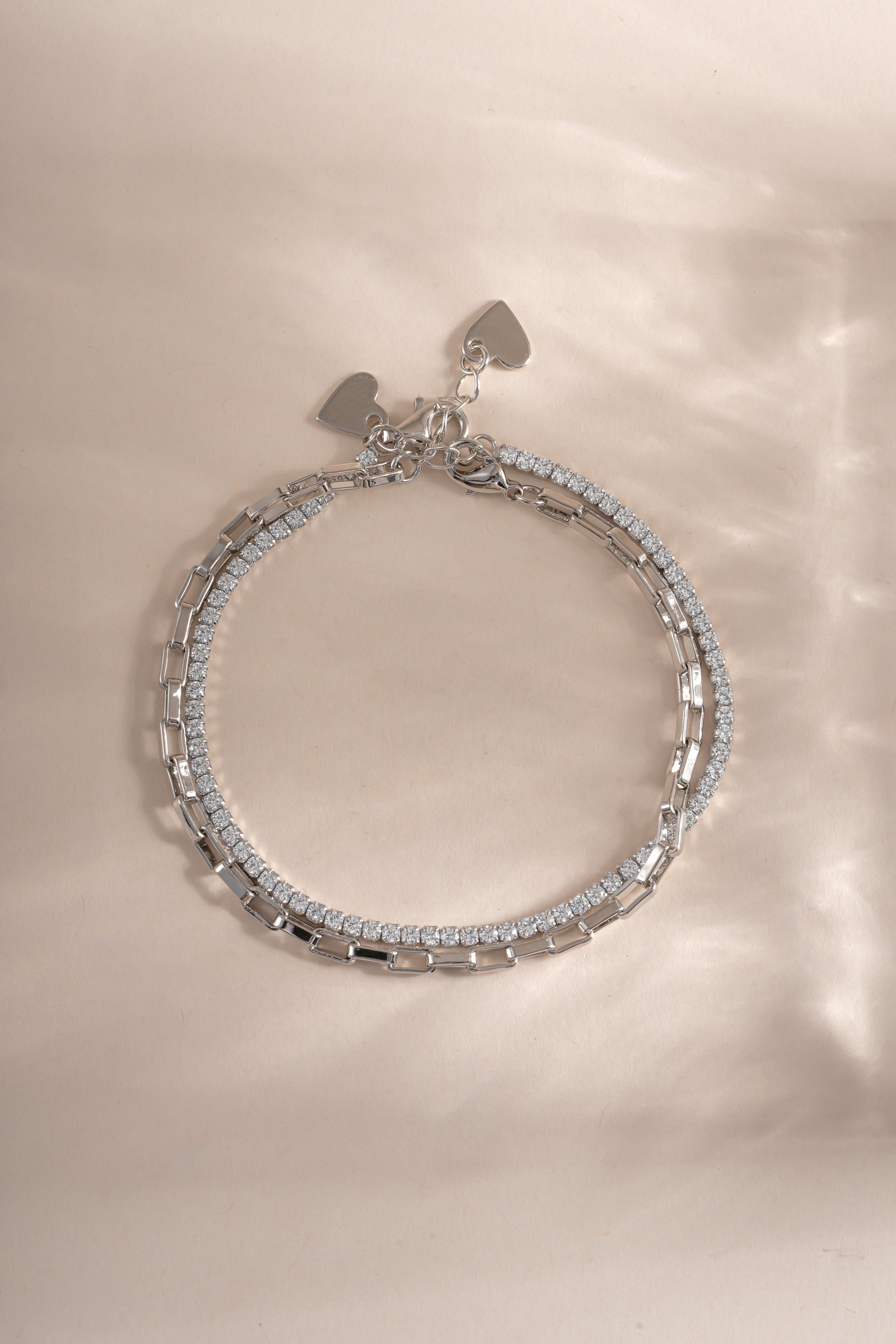 Close-up of Sami Jewels Sterling Silver Tennis & Paperclip Bracelet Set showcasing sleek, modern bracelet designs on a neutral background.