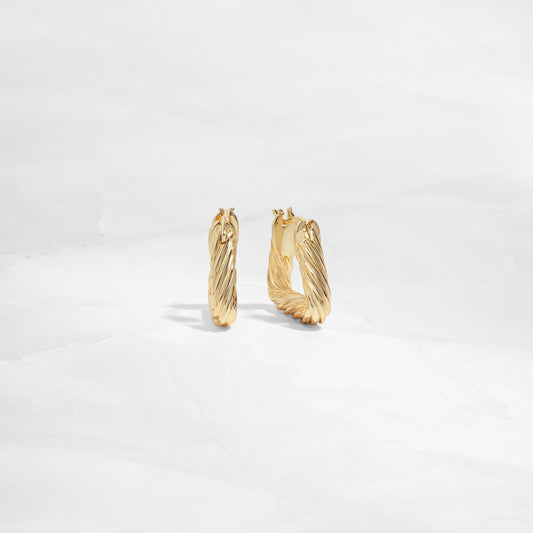 Side and front profile of chunky gold hoop earrings with a geometric design.