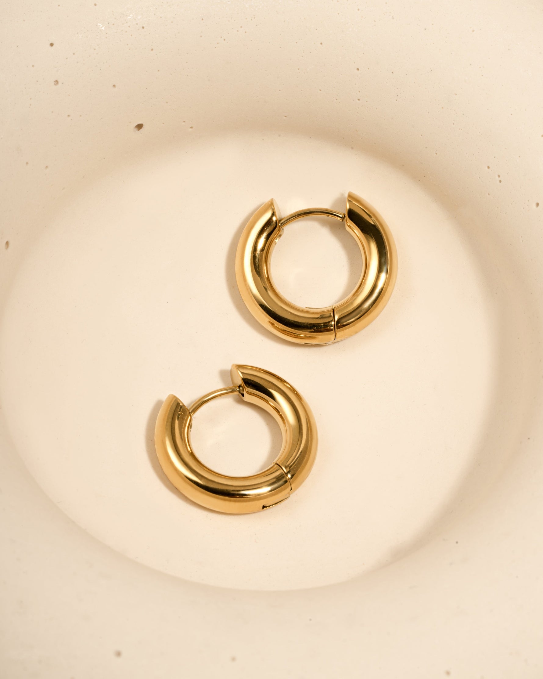 Close-up of gold stainless steel SS hoops earrings by Sami Jewels, showcasing thick huggie-style design and waterproof finish.