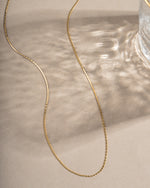 Gold thin chain necklace from Sami Jewels, close-up of delicate, lightweight jewelry on a neutral background.