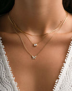 Gold thin chain necklace from Sami Jewels worn layered on a model, showcasing delicate and elegant jewelry design.