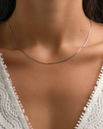 Sterling silver thin chain necklace from Sami Jewels displayed on a model. Elegant jewelry accessory for everyday wear.