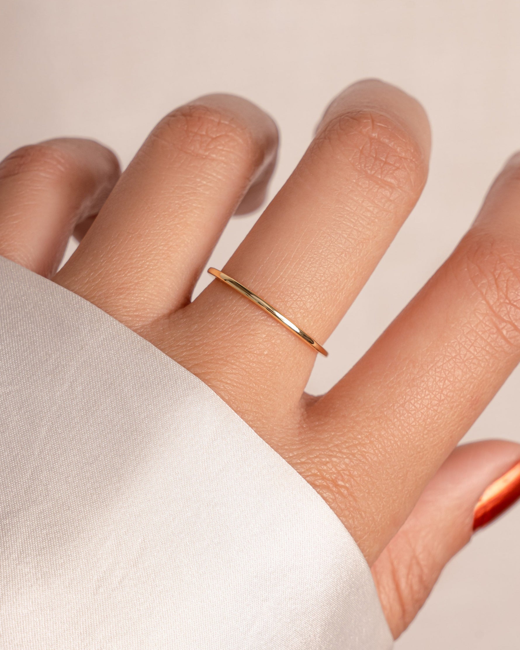 Gold thin plain band ring from Sami Jewels, close-up of sleek, minimalist design on a model's finger