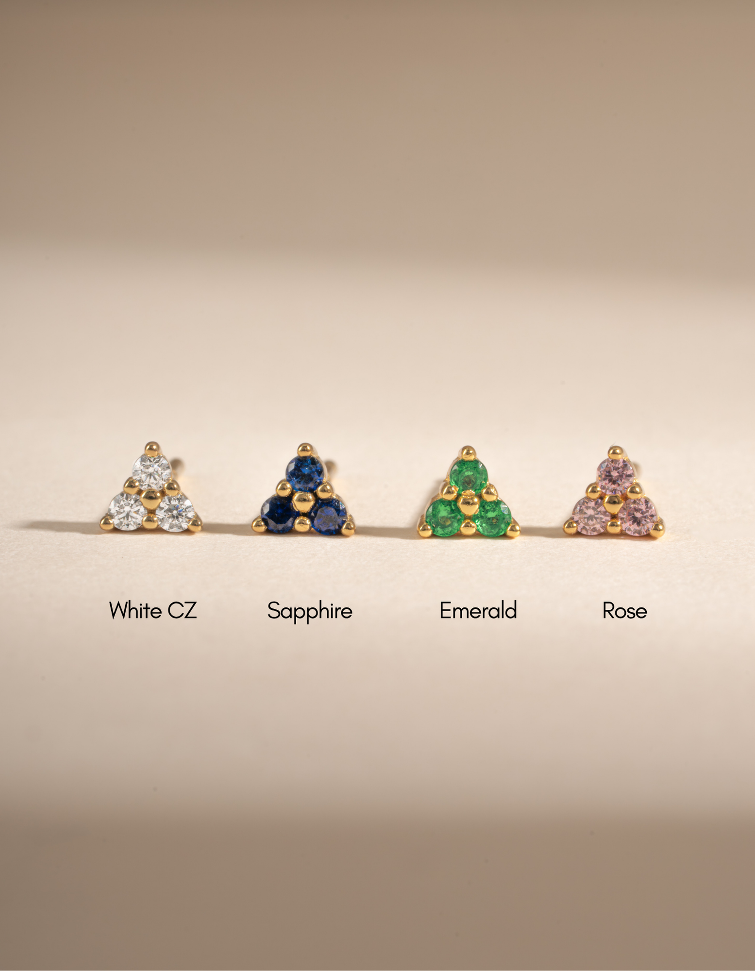 Tiny Emerald 3 Stone Stud Earrings by Sami Jewels featuring gold setting and three sparkling emerald stones.