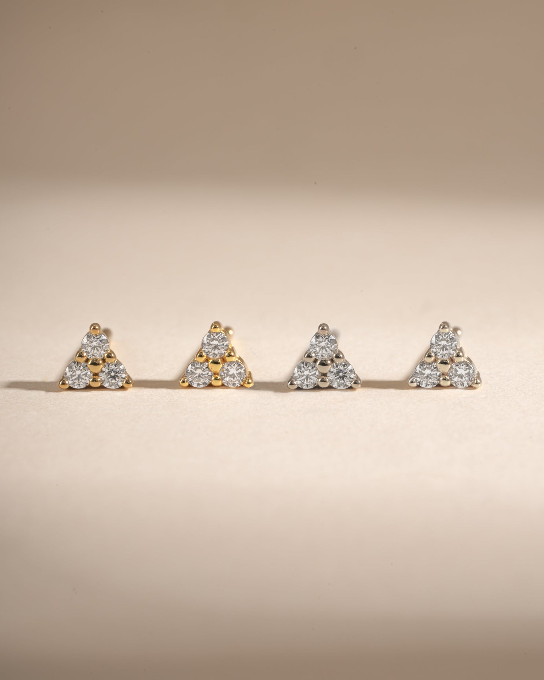 Sterling silver and gold three-stone CZ stud earrings by Sami Jewels featuring sparkling cubic zirconia stones.