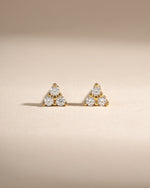 Close-up of Sami Jewels Tiny CZ 3 Stone Stud Earrings in gold, showcasing three sparkling cubic zirconia stones on each earring.