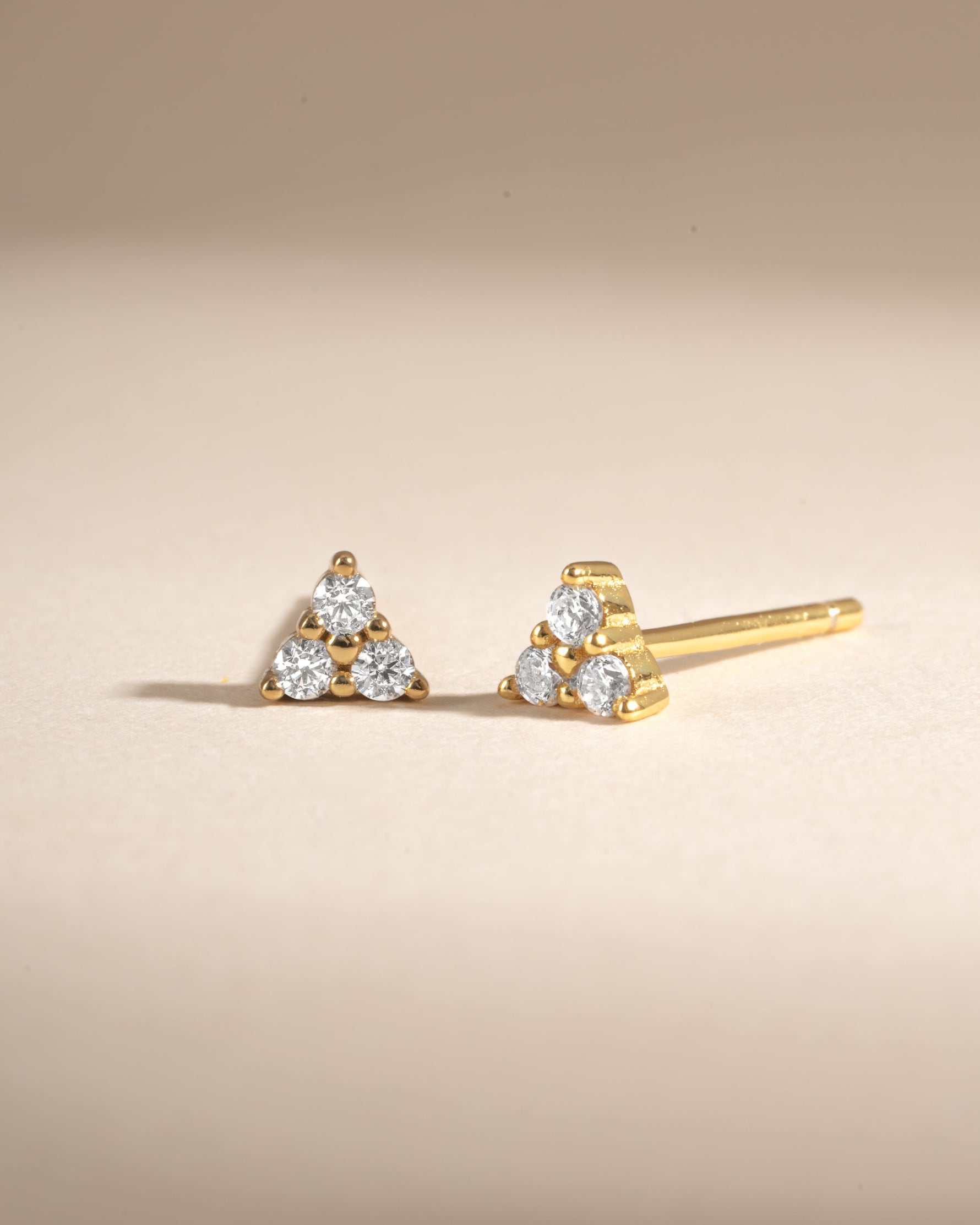 Gold Tiny CZ 3 Stone Stud Earrings by Sami Jewels featuring sparkling cubic zirconia stones in a three-stone setting.